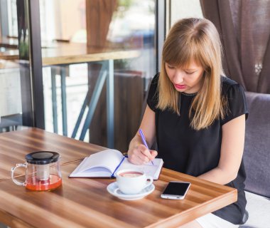 çay içme ve iş kağıtları ile çalışan kadın