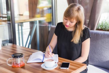 çay içme ve iş kağıtları ile çalışan kadın