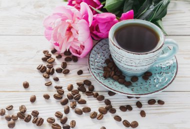 Fincan kahve, kahve çekirdekleri ve peonies