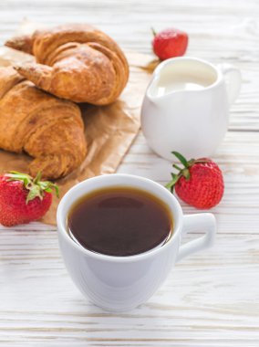 Fincan kahve, kruvasan, çilek ve süt kavanoz