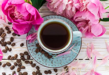 Fincan kahve, kahve çekirdekleri ve peonies