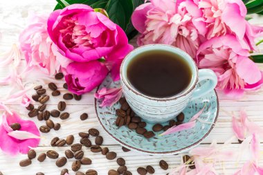 Fincan kahve, kahve çekirdekleri ve peonies
