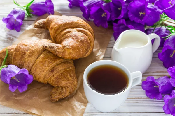 Cup of coffee, croissants, milk jar and lilac flowers — Stock Photo, Image