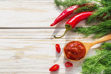 Domates sosu salsa, sıcak biber, dereotu ve fesleğen, ahşap backgr üzerinde