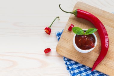 Domates sosu salsa, sıcak biber ve fesleğen, ahşap arka plan üzerinde