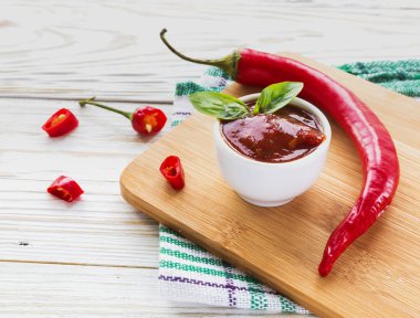 Domates sosu salsa, sıcak biber ve fesleğen, ahşap arka plan üzerinde