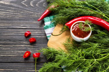 Domates sosu salsa, sıcak biber, dereotu ve fesleğen, ahşap backgr üzerinde