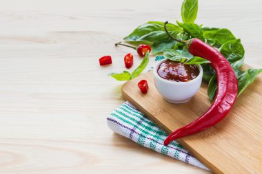 Domates sosu salsa, sıcak biber ve fesleğen, ahşap arka plan üzerinde