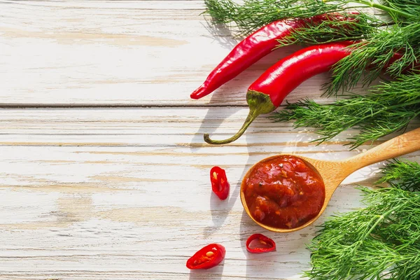 Domates sosu salsa, sıcak biber, dereotu ve fesleğen, ahşap backgr üzerinde