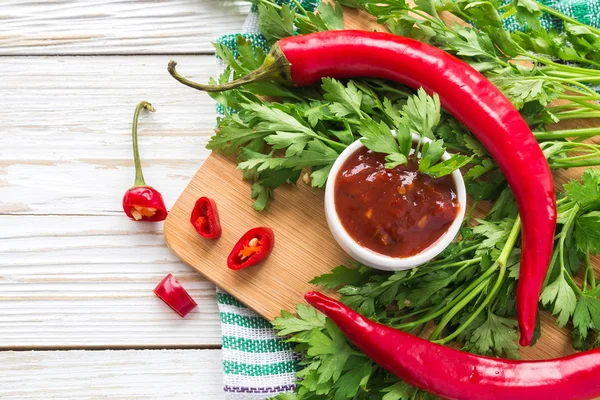 Domates sosu salsa, sıcak biber, maydanoz, fesleğen, ahşap bac üzerinde