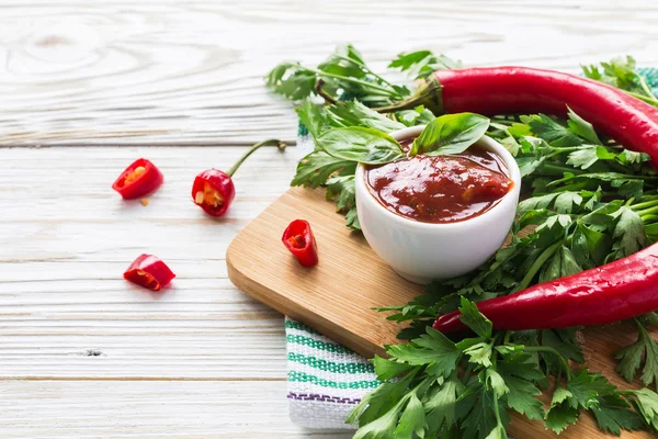 Domates sosu salsa, sıcak biber, maydanoz, fesleğen, ahşap bac üzerinde
