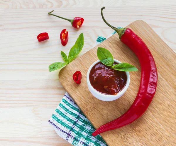 Domates sosu salsa, sıcak biber ve fesleğen, ahşap arka plan üzerinde — Stok fotoğraf