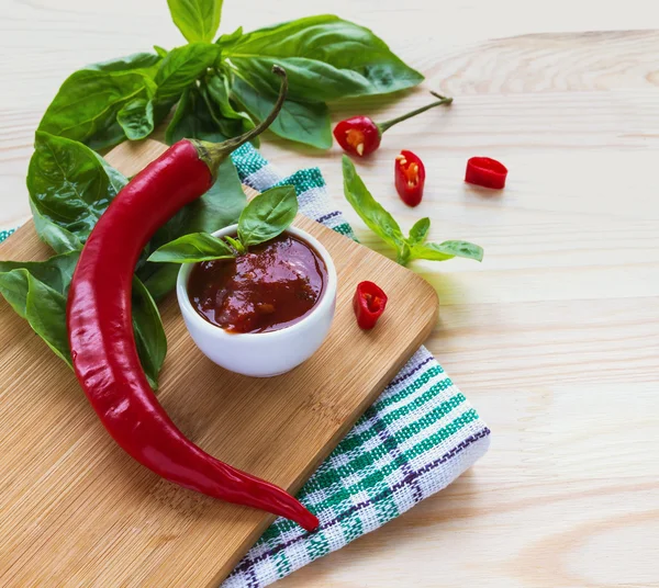 Domates sosu salsa, sıcak biber ve fesleğen, ahşap arka plan üzerinde
