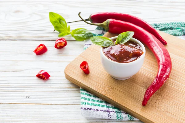 Domates sosu salsa, sıcak biber ve fesleğen, ahşap arka plan üzerinde