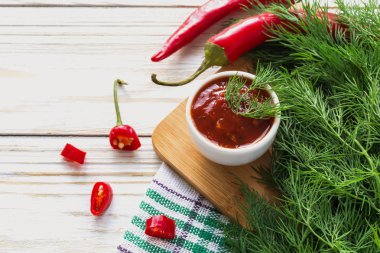 Domates sosu salsa, sıcak biber, dereotu ve fesleğen, ahşap backgr üzerinde