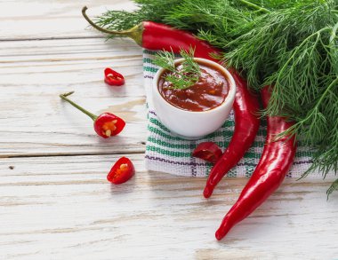 Domates sosu salsa, sıcak biber, dereotu ve fesleğen, ahşap backgr üzerinde