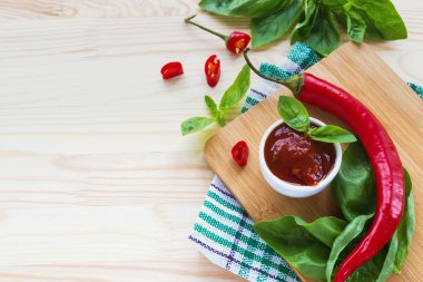 Domates sosu salsa, sıcak biber ve fesleğen, ahşap arka plan üzerinde