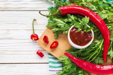 Domates sosu salsa, sıcak biber, maydanoz, fesleğen, ahşap bac üzerinde