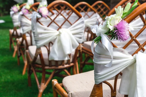 Γάμος καρέκλες διακοσμημένα με λουλούδια. Κοντινό πλάνο. — Φωτογραφία Αρχείου
