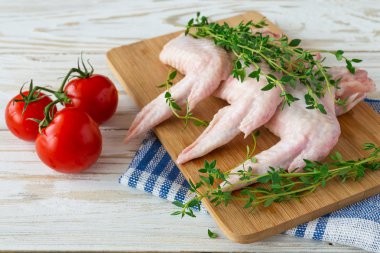 Çiğ tavuk kanatları kekik, kırmızı biber, biber ve domates ile 