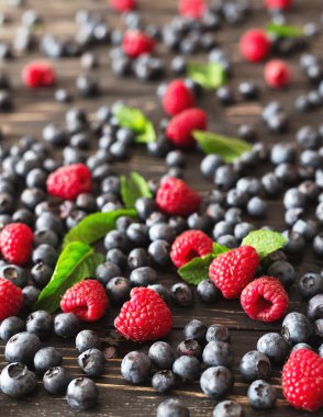 Yaban mersini, ahududu ve nane, siyah ahşap masa. 