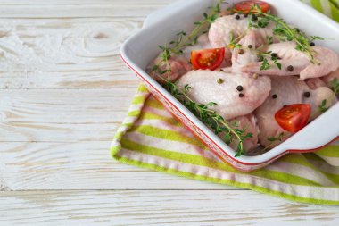 Çiğ tavuk kanatları kekik, kırmızı biber, biber ve domates ile 