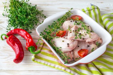 Çiğ tavuk kanatları kekik, kırmızı biber, biber ve domates ile 