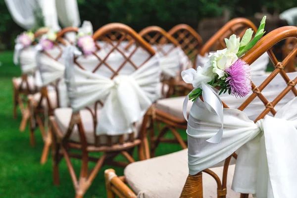 Γάμος καρέκλες διακοσμημένα με λουλούδια. Κοντινό πλάνο. — Φωτογραφία Αρχείου