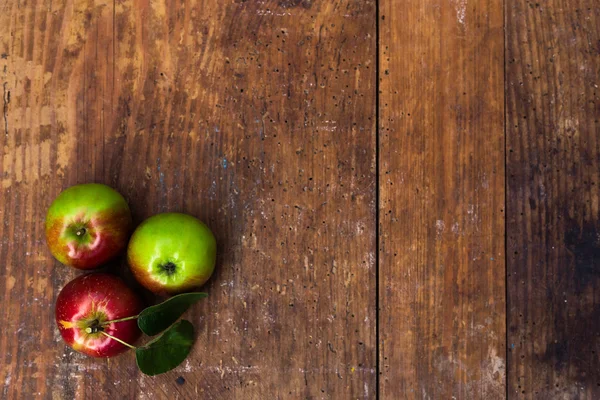 Rote reife Äpfel an dunklem Holztisch. — Stockfoto