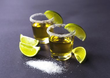Limon ve tuz karanlık masada altın tekila