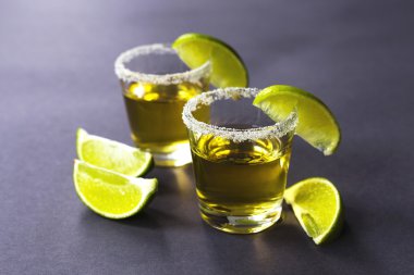 Limon ve tuz karanlık masada altın tekila