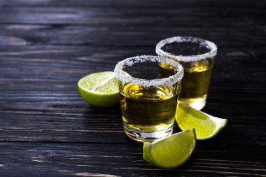 Limon ve tuz karanlık masada altın tekila