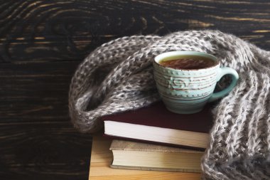 Sıcak örme şal, fincan çay ve kitaplar