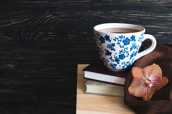 Meleg kötött kockás, csésze tea és könyvek — Stock Fotó