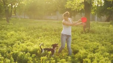 Güzel kız bahçede köpekle oynayan bir frizbi atma