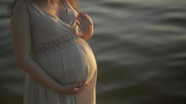 Красивая беременная женщина на берегу реки — стоковое видео