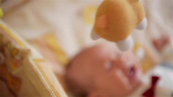 Kleine schattige babyjongen liggend in bedje met speelgoed, jongen huilen — Stockvideo