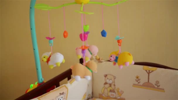 Kleine schattige babyjongen liggend in bedje met speelgoed — Stockvideo