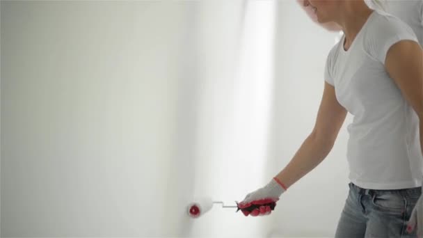 Pareja joven decorar su nuevo apartamento.Están pintando la pared — Vídeos de Stock