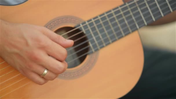 Hombre tocando la guitarra al aire libre, humor romántico, instrumento musical, primer plano — Vídeo de stock