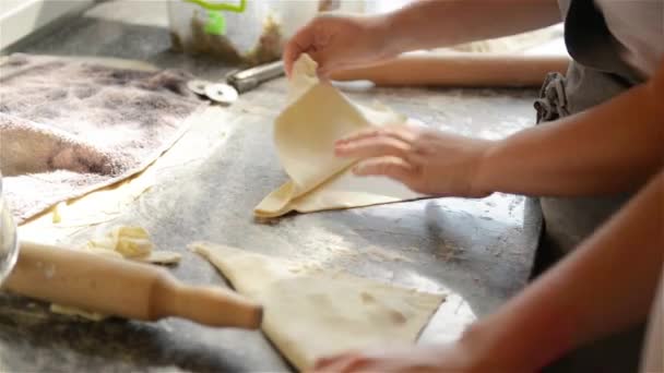 Два повара работают с тестом, приготовленные пирожки на профессиональной кухне — стоковое видео