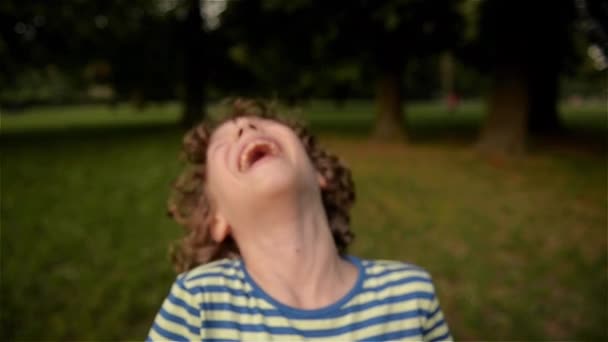 Leuke jongen lachen in het park, close-up, slow-motion — Stockvideo