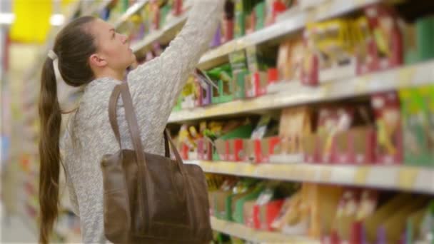 Giovane donna che sceglie spezie nel negozio di alimentari, bella donna che fa shopping in un supermercato — Video Stock