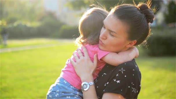 Jovem bela mãe abraçando e confortando sua filha bebê, abraços de mãe bebê, mulher acalma menina — Vídeo de Stock