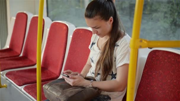 Piękna młoda kobieta podróży w transporcie miejskim i za pomocą jej telefon komórkowy. Kobieta za pomocą smartfona w transporcie publicznym — Wideo stockowe