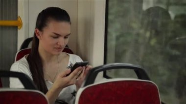 Otobüs yolculuğu sırasında kentsel ulaşım seyahat ve cep telefonu kullanarak güzel kadın akıllı telefon kullanan genç kız
