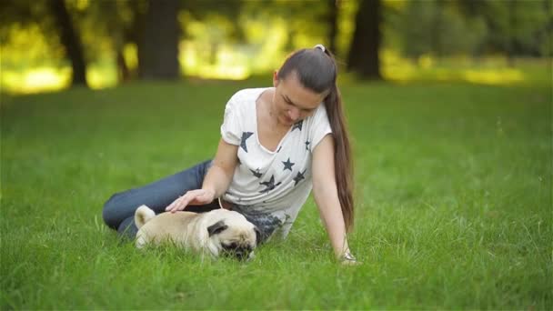 Mãe e criança brincando com o cão em um dia quente de verão, mamãe com a filha acariciando pequenas esfregonas no parque, sol — Vídeo de Stock