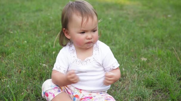 Плачущий маленький ребенок в парке, милая девушка, к сожалению, проводит время на открытом воздухе в теплый летний день — стоковое видео