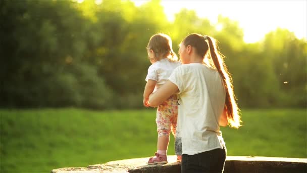 日当たりの良い自然、ママと欄干に立つ娘で一緒に楽しむ子供と幸せな母 — ストック動画
