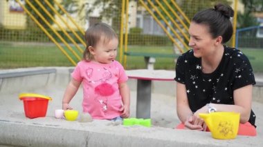 Aile iki oyun ve bir yaz günü, güzel genç anne çocukları açık zaman harcıyor sandbox şekil verme büyüleyici